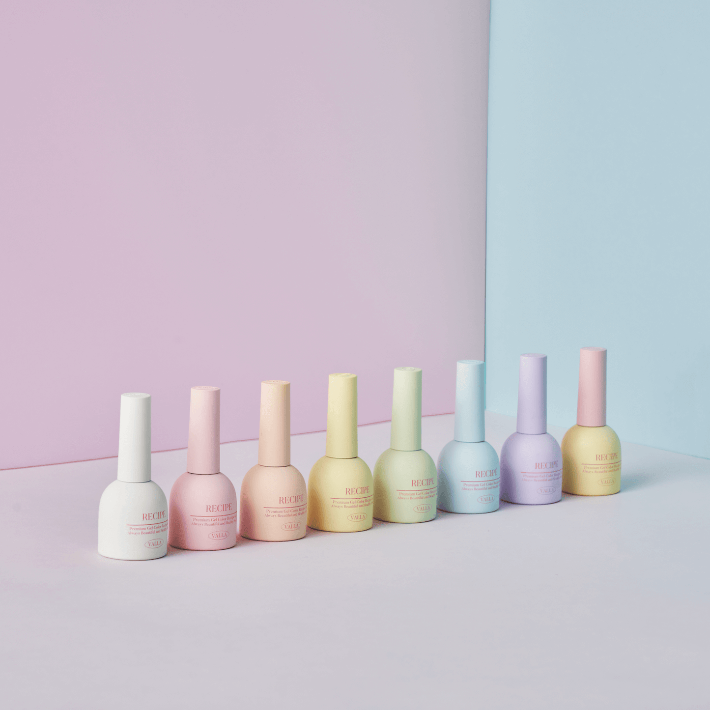 Flatlay of Valla Gel Cotton Pastel bottles on a striped pastel background – trendy product shoot